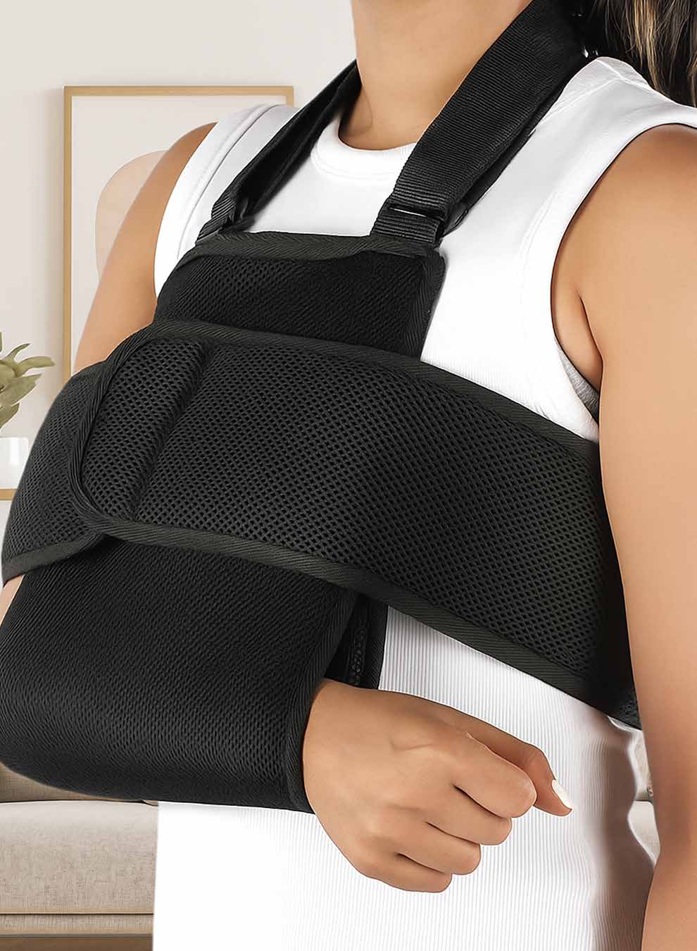 Model wearing the black mesh shoulder immobilizer sling holding the arm across the body.